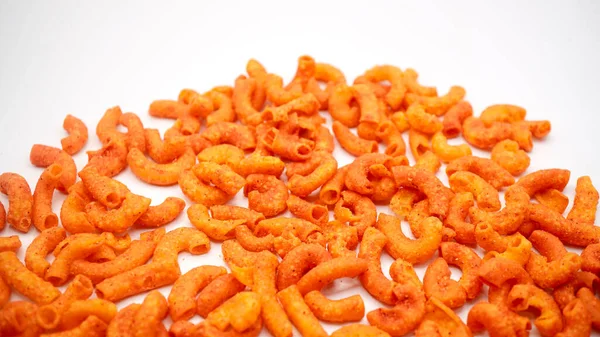 Acı biber soslu kızarmış makarna cipsi, temiz beyaz arka planda izole edilmiş.