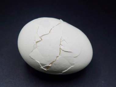 Haşlanmış yumurtanın kabuk dokusunu gösteren yakın plan görüntüsü. Yemek hazırlama, organik diyet, kırsal mutfak ve sağlıklı yemek temaları için idealdir.