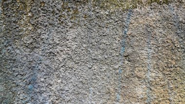 Görünür dokusu, çatlakları ve doğal hava koşulları olan sert, gri beton bir duvara yakın çekim. Arkaplan, soyut yüzey ya da grunge doku tasarım ögesi olarak kullanmak için ideal