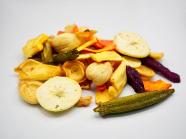 Kurutulmuş meyve ve sebze cipsi karışımı beyaz arka planda düzenlenmiş. Sağlıklı gıda pazarlaması, vejetaryen yaşam tarzı ve atıştırmalık tasarımı için uygun