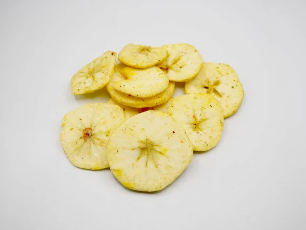 Temiz beyaz bir yüzeye düzgünce yerleştirilmiş ince kurumuş elma parçaları. Sağlıklı yiyecekleri, meyve atıştırmalıklarını, doğal beslenme düzenini ve organik yaşam tarzını göstermek için birebirdir.