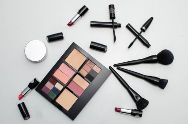 Gözler için siyah rimel, merdiven, ruj, göz farı paleti, makyaj fırçası, beyaz arka planda izole edilmiş.