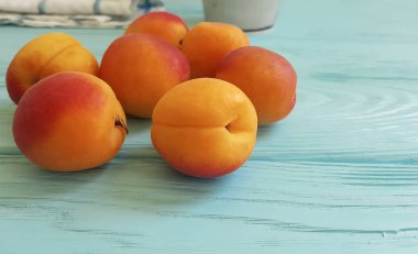 Mavi ahşap arka plan üzerinde taze kayısı