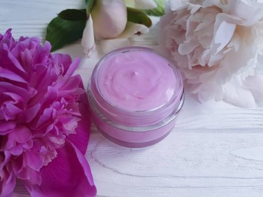 Krem Kozmetik şakayık çiçekleri Beyaz ahşap zemin üzerinde