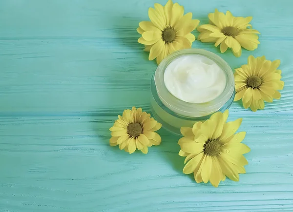 Crème Cosmetische Gele Bloemen Een Blauwe Houten Achtergrond — Stockfoto