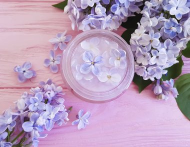 pembe ahşap arka plan üzerinde kozmetik krem Lila çiçek