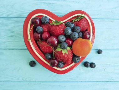 meyve çilek, yaban mersini, kiraz, kayısı plaka kalp mavi ahşap