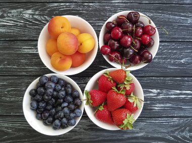 kiraz, kayısı, yaban mersini eski bir kara tahta üzerinde çilek