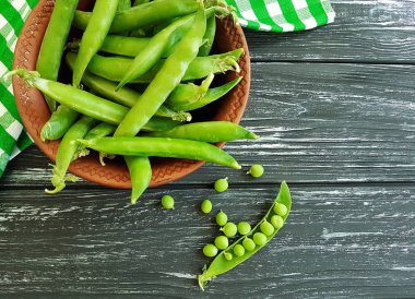 taze yeşil bezelye bulaşık siyah bir ahşap zemin üzerine bir havlu