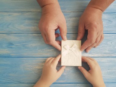 Babalar günü el baba ve çocuk hediye kutusu mavi ahşap arka plan üzerinde