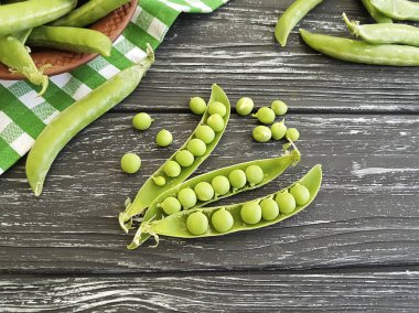 Siyah ahşap arka planda taze yeşil bezelye