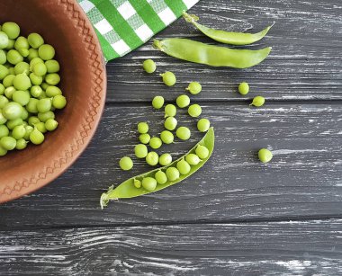 Siyah ahşap arka planda taze yeşil bezelye
