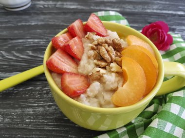 Yulaf ezmesi, fındık, siyah ahşap arka planda çilek