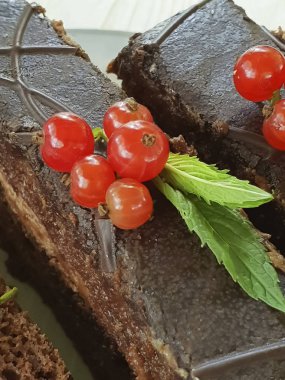 çikolata kek, kırmızı frenk üzümü, Beyaz ahşap üzerinde nane plaka