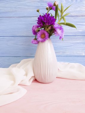 çiçek çan ile vazo, ahşap bir arka planda mor krizantem