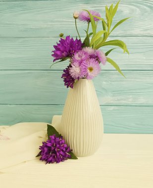 çiçek çan ile vazo, ahşap bir arka planda mor krizantem