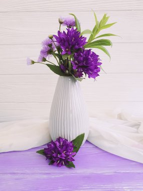 çiçek çan ile vazo, ahşap bir arka planda mor krizantem