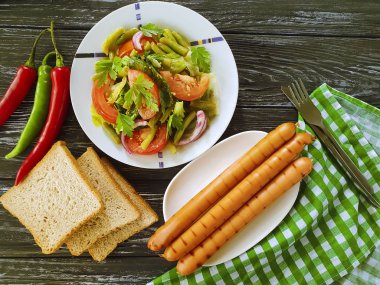 salata fasulye, domates, kızarmış sosis ahşap arka plan üzerinde
