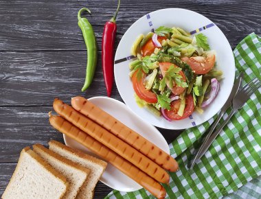 salata fasulye, domates, kızarmış sosis ahşap arka plan üzerinde