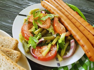 salata fasulye, domates, kızarmış sosis ahşap arka plan üzerinde