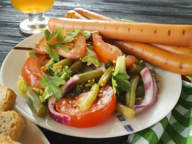salata fasulye, domates, kızarmış sosis, bira ahşap arka plan üzerinde