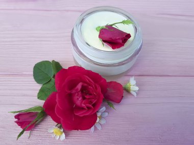 ahşap arka plan üzerinde kozmetik krem gül papatya