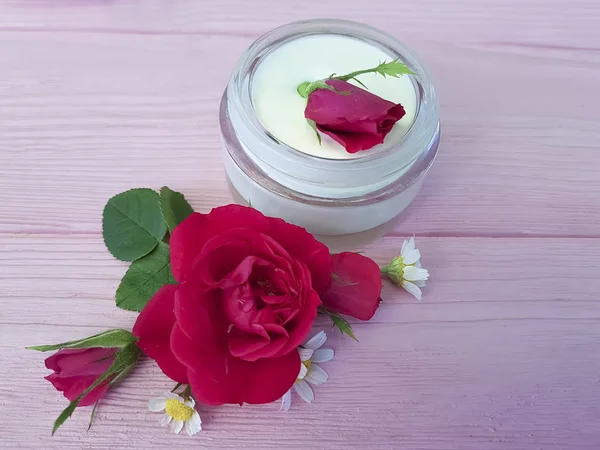 ahşap arka plan üzerinde kozmetik krem gül papatya