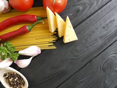 Spagetti, sarımsak domates siyah ahşap zemin