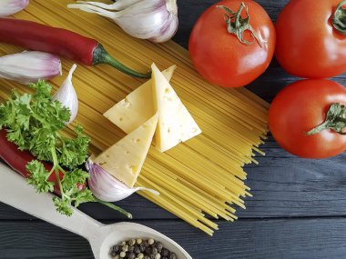Spagetti, sarımsak domates siyah ahşap zemin