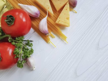 Spagetti, domates, sarımsak, biber, tereyağı, peynir ahşap arka plan üzerinde