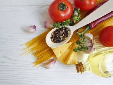 Spagetti, domates, sarımsak, biber, tereyağı, peynir ahşap arka plan üzerinde