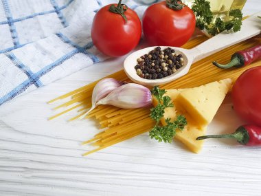 Spagetti, domates, sarımsak, biber, tereyağı, peynir ahşap arka plan üzerinde
