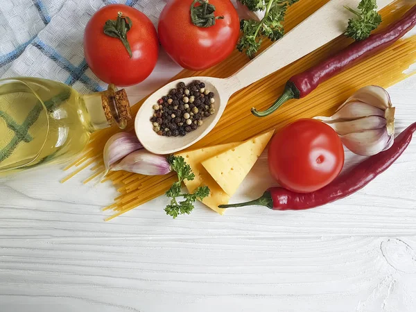 Spagetti, domates, sarımsak, biber, tereyağı, peynir ahşap arka plan üzerinde
