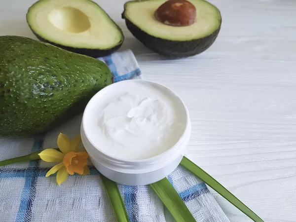 Krem Kozmetik, ahşap arka plan üzerinde avokado, çiçek