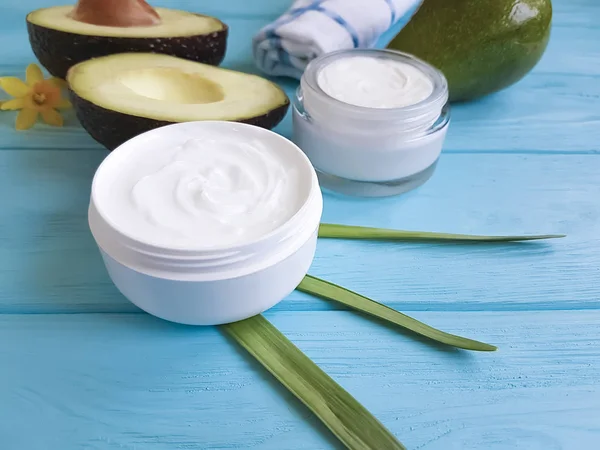 Krem Kozmetik, ahşap arka plan üzerinde avokado, çiçek