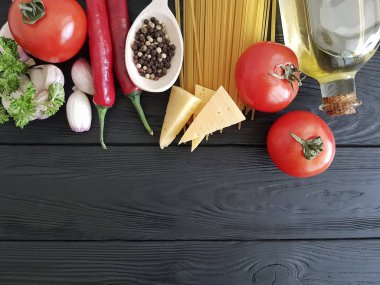 Spagetti, domates, sarımsak, peynir siyah ahşap zemin