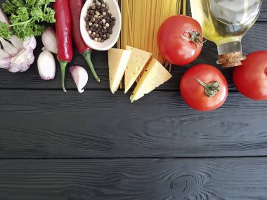 Spagetti, domates, sarımsak, peynir siyah ahşap zemin
