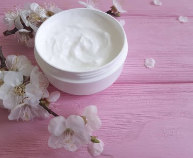 pembe ahşap arka plan üzerinde kozmetik krem çiçek açması kiraz