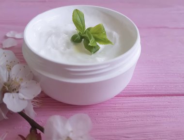 pembe ahşap arka plan üzerinde kozmetik krem çiçek açması kiraz