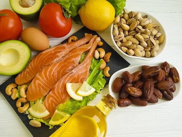 red fish, avocado, nuts on a wooden background