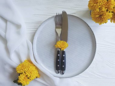 tabak, çatal, bıçak kasımpatı çiçekleri Beyaz ahşap zemin üzerinde