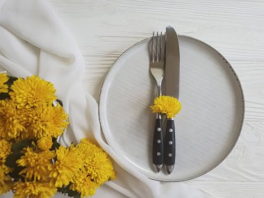 tabak, çatal, bıçak kasımpatı çiçekleri Beyaz ahşap zemin üzerinde