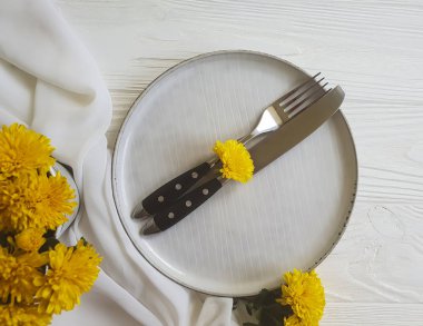 tabak, çatal, bıçak kasımpatı çiçekleri Beyaz ahşap zemin üzerinde