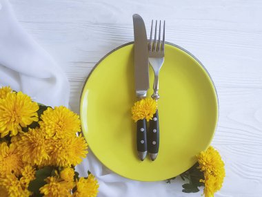 tabak, çatal, bıçak kasımpatı çiçekleri Beyaz ahşap zemin üzerinde