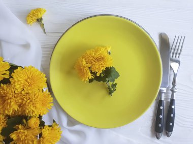 tabak, çatal, bıçak kasımpatı çiçekleri Beyaz ahşap zemin üzerinde