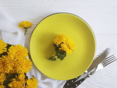 tabak, çatal, bıçak kasımpatı çiçekleri Beyaz ahşap zemin üzerinde