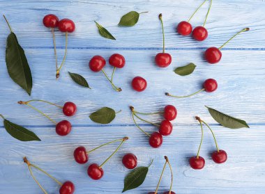 olgun kiraz berry bir mavi ahşap arka plan üzerinde desen