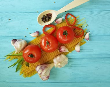 Spagetti, domates, sarımsak mavi ahşap arka plan üzerinde