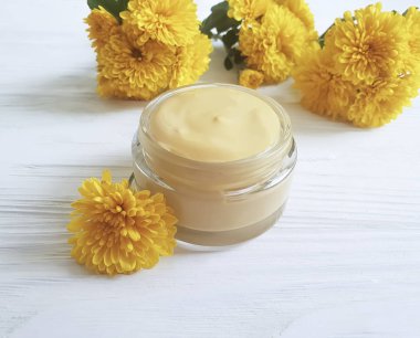 Beyaz ahşap zemin üzerinde doğal kozmetik krem, Sarı Krizantem