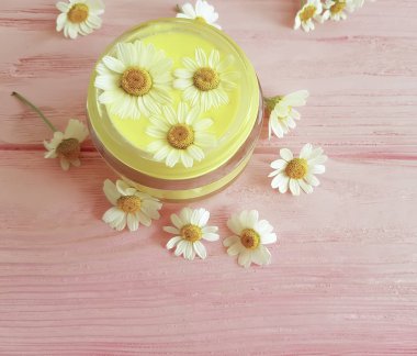 papatya çiçek, pembe ahşap arka plan üzerinde kozmetik krem